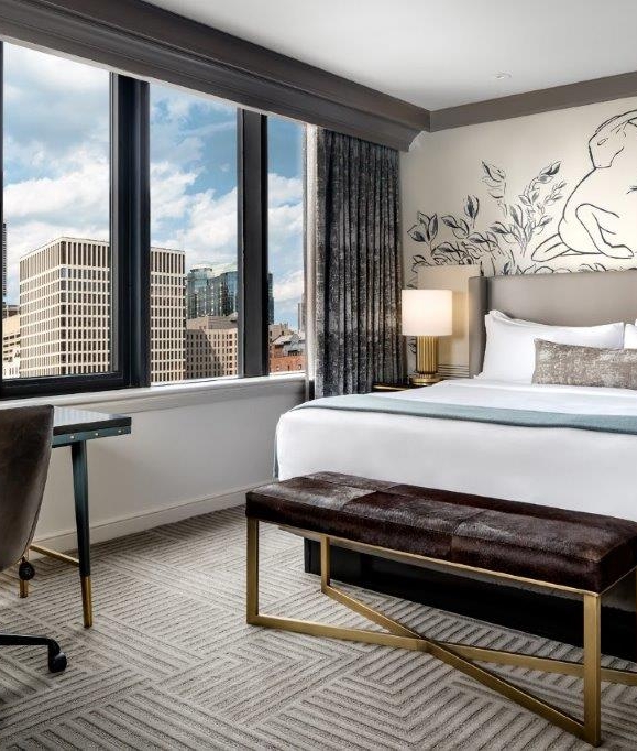 Bedroom with a large window showing off the Chicago cityscape